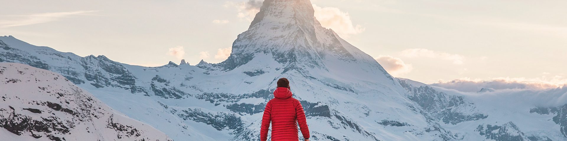 Un homme de so face à une montagne enneigée