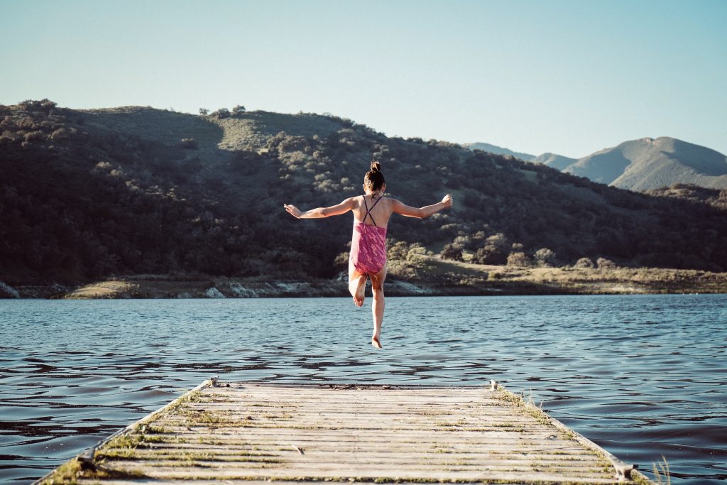 Petite fille qui saute dans l'eau, dans un lac de montagne